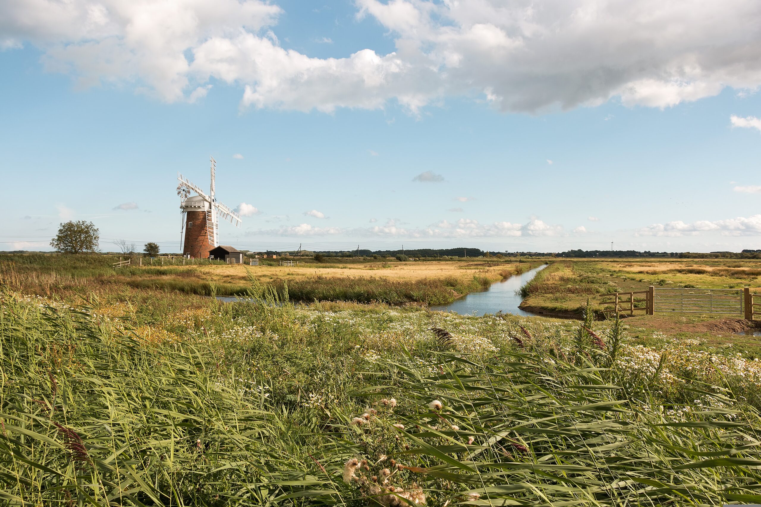Traditional British farmland landscape with a rural windmill and open fields